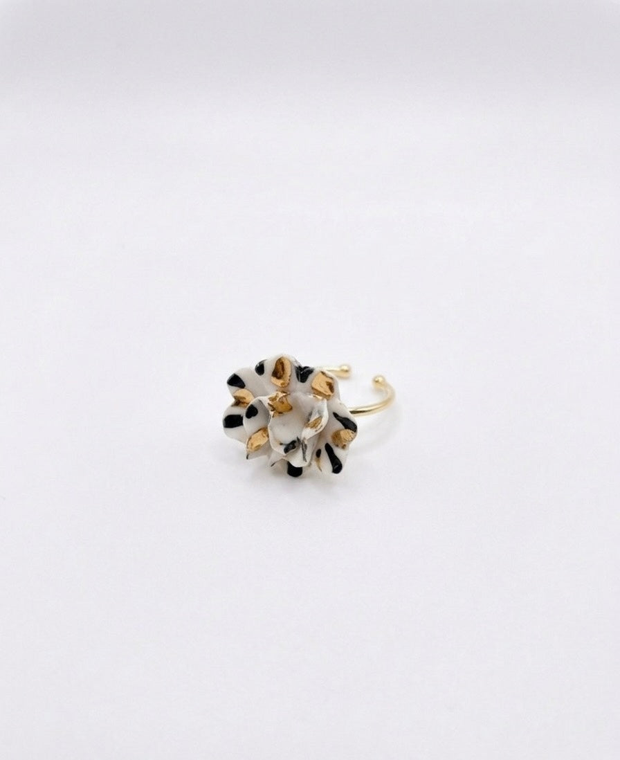 White and black speckled floral enamel ring with a gold band