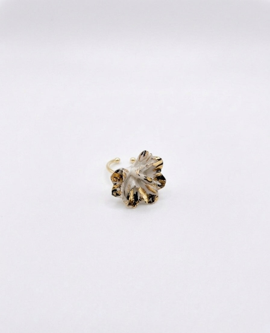 A white and gold textured floral ring on a plain white background