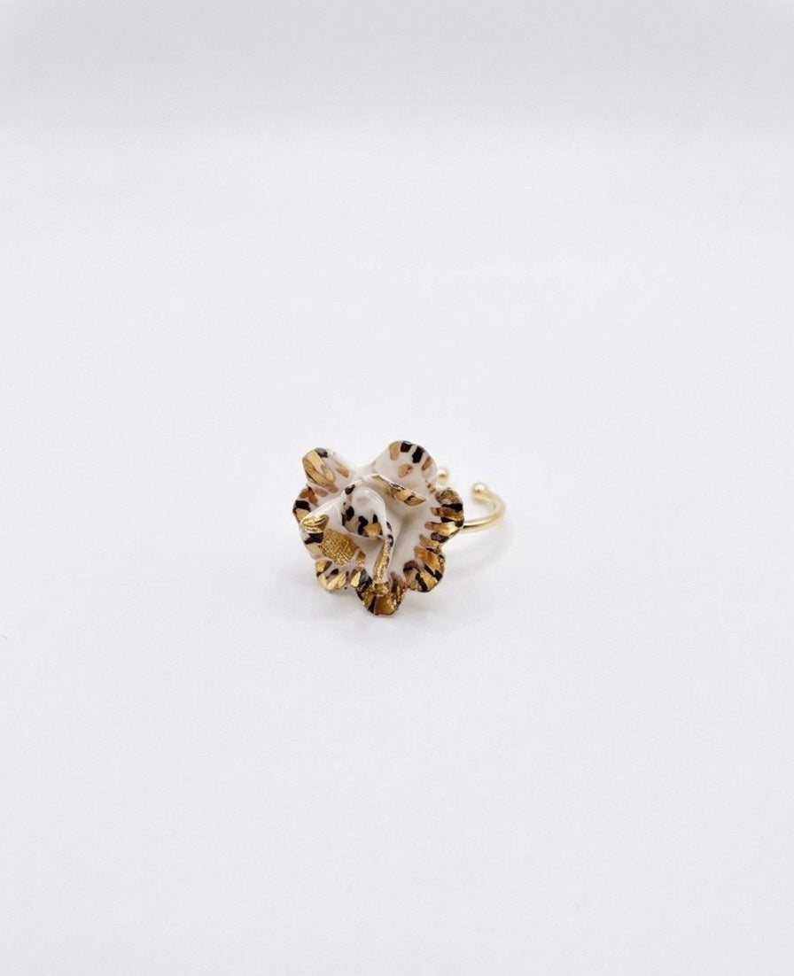 Gold ring with a white and gold speckled flower design